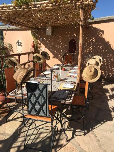 a table and chairs under an umbrella on a patio at Riad Dar Bab Todra in Tinerhir