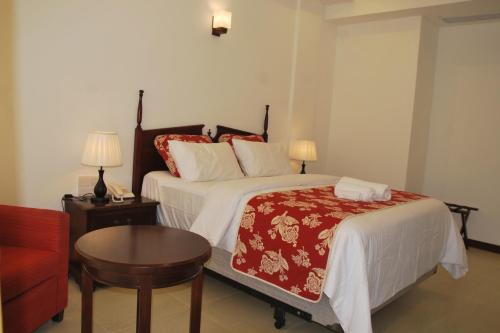a hotel room with a bed and a table at Bayfront in Weligama