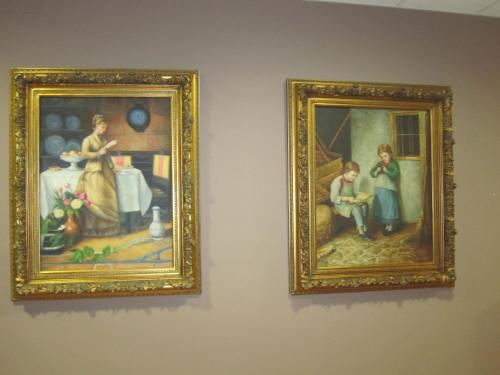 two framed paintings of people on a wall at Hotel Finca La Mansión in Llanes