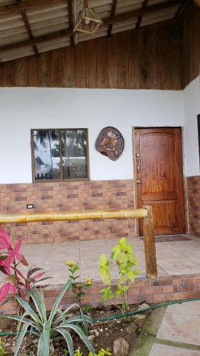 a front porch of a house with a wooden door at Hugo's Relax Home (Casa) in Ayangue