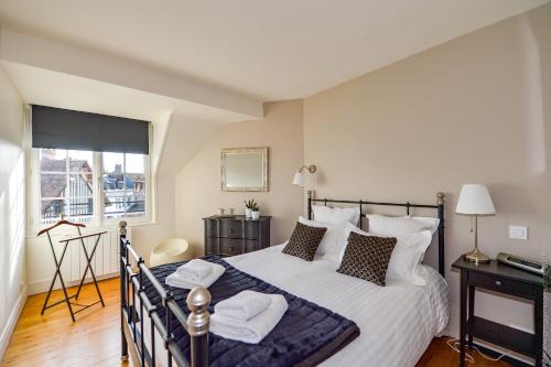 ein Schlafzimmer mit einem großen Bett mit weißen Laken und Kissen in der Unterkunft La Maison de Pierre et Valérie Ste Catherine Honfleur in Honfleur