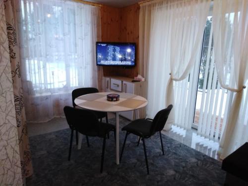 a dining room with a table and chairs and a tv at Mustvee Creek Cottage in Mustvee