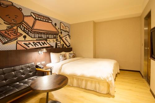 a hotel room with a bed and a couch at Just Live Inn-Taipei Station in Taipei