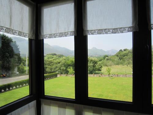 a window with a view of a green field at Hotel Finca La Mansión in Llanes