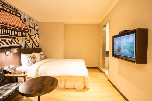 a hotel room with a bed and a television at Just Live Inn-Taipei Station in Taipei