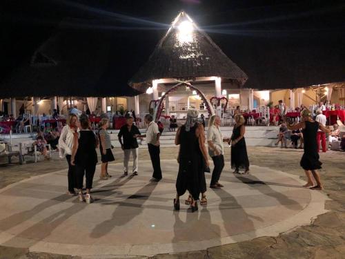 a group of people standing on a dance floor at night at Karibuni Hotel & Villas in Mambrui