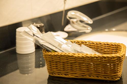 a basket of toothbrushes sitting next to a sink at Just Live Inn-Taipei Station in Taipei