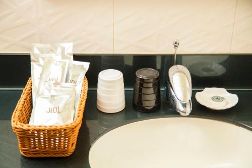 a bathroom counter with a basket of toiletries and a sink at Just Live Inn-Taipei Station in Taipei