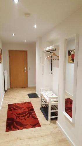 a living room with a red rug and a door at Haus Moritzburg in Bad Schandau