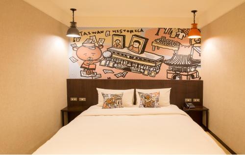 a bedroom with a bed with a painting on the wall at Just Live Inn-Taipei Station in Taipei