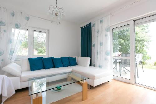 un soggiorno con divano bianco e cuscini blu di Villa Oleander a Marina