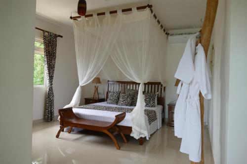 a bedroom with a bed with a canopy at Villa Karibu in Au Cap