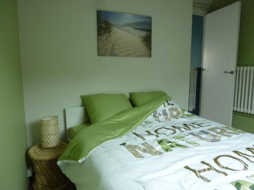 una camera con letto e lenzuola bianche e verdi di Gîte "L'Escapade Marine" a Cancale