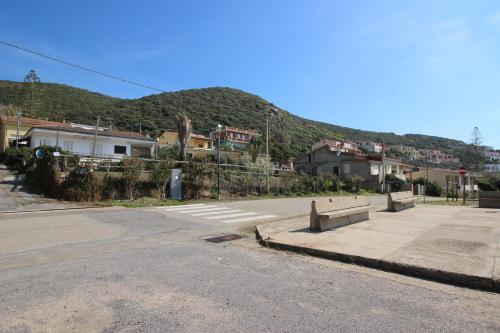 an empty street with houses and a mountain at Appartamento Oleandro Piccolo Gutturu in Marina di Arbus