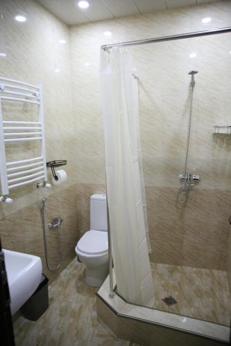 a bathroom with a shower and a toilet and a sink at X Palace in Tbilisi City