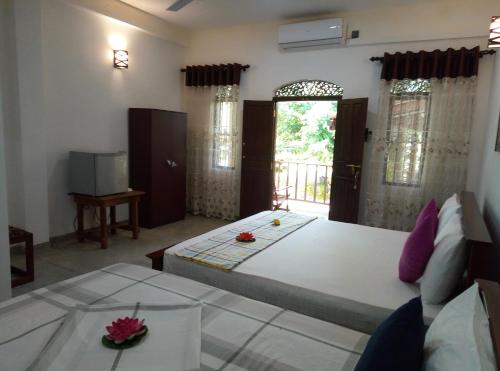 a bedroom with a large bed and a balcony at Ging View Villa in Galle