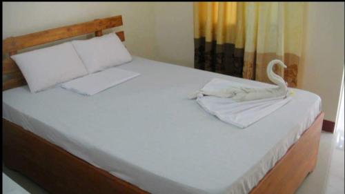 een slaapkamer met een bed met een zwaan erop bij AJ Travellers Inn - Annex in Boracay