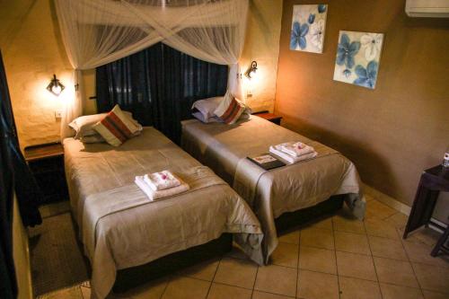a room with two beds in a hotel room at Island Safari Lodge in Maun