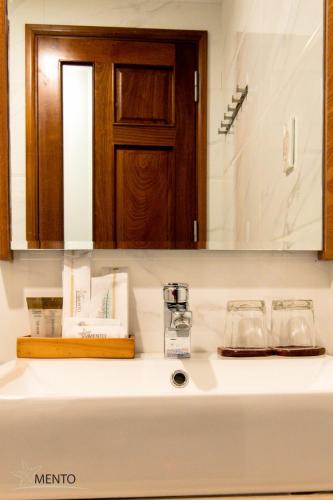 a bathroom counter with a sink and a mirror at MENTO HOTEL QUY NHƠN in Quy Nhon