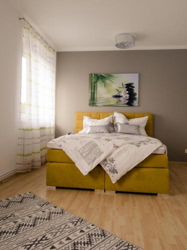 ein Schlafzimmer mit einem Bett mit einem gelben Fußbrett in der Unterkunft Ferienwohnung Koller in Wernberg
