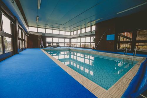 - une grande piscine dans un bâtiment aux sols bleus dans l'établissement Crispie House, à Kilfinan