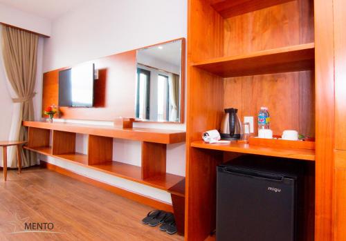 a bathroom with wooden shelves and a mirror at MENTO HOTEL QUY NHƠN in Quy Nhon
