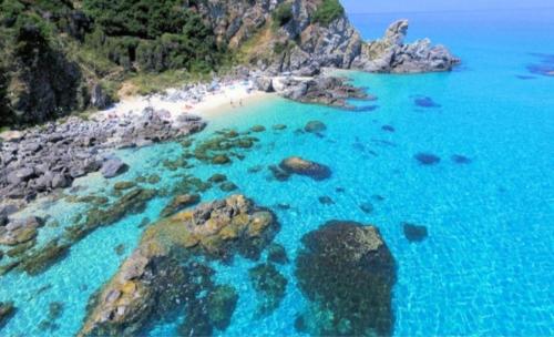 uma vista aérea de uma praia com rochas e água azul em Casa Staropoli em Sciconi