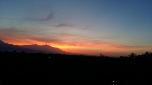 a sunset with a mountain in the background at Anyar in Mataram
