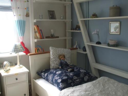 una muñeca sentada en una almohada en un dormitorio en Appartement Seelücke, en Glücksburg