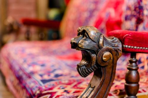 a close up of a wooden chair next to a bed at Tiflis Inn Boutique Hotel in Tbilisi City
