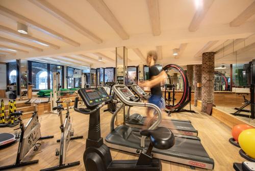 a woman in a gym with cardio equipment at Hotel Land Gut Höhne in Mettmann