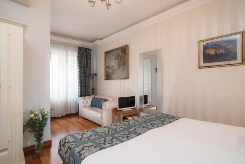 ローマにあるSotto La Cupolaのベッドとソファ付きのホテルルーム