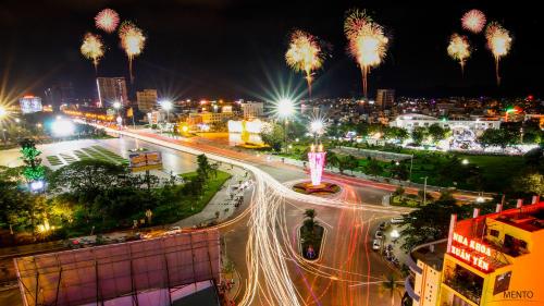 a city at night with street lights and palm trees at MENTO HOTEL QUY NHƠN in Quy Nhon