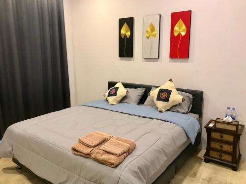 a bedroom with a bed with towels on it at Aly’s house in Ban Phlu Thong