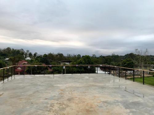 a large concrete patio with trees in the background at Aly’s house in Ban Phlu Thong