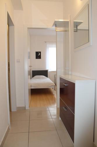 a bathroom with a sink and a mirror in a room at Apartman M&M in Stara Novalja