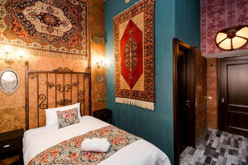 a bedroom with a bed and a rug on the wall at Tiflis Inn Boutique Hotel in Tbilisi City