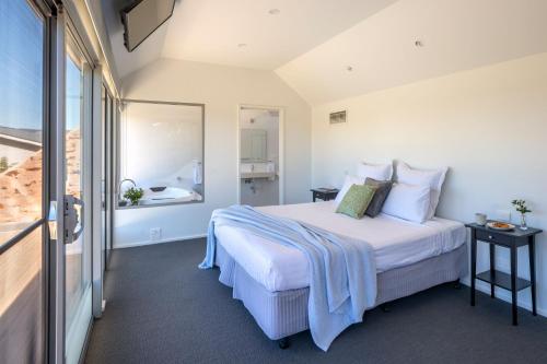 a bedroom with a large white bed with a window at Barossa Shiraz Estate in Lyndoch