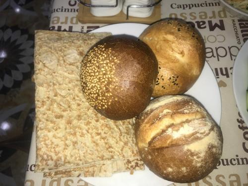 three breads on a plate on a table at Hotel Victoria in Yerevan
