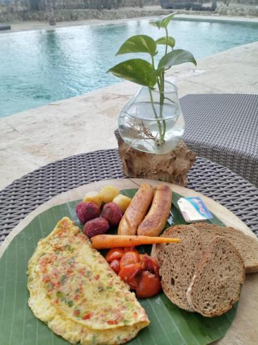 Rua Beach Resort Sumba في Rua: طبق من الطعام مع الخبز والخضار على الطاولة