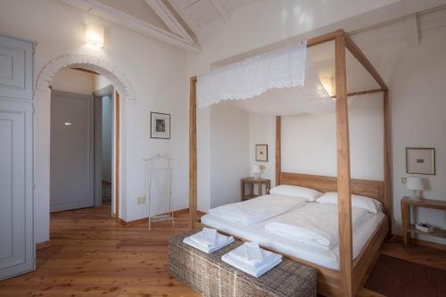 a bedroom with a canopy bed and a wooden floor at Oasi Picolit in Povoletto