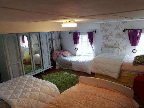 a bedroom with three beds and a mirror at Bernadette in Chouvigny