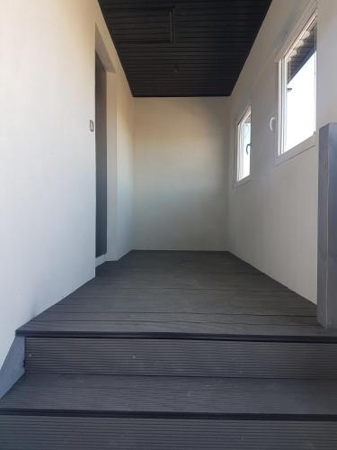 an empty room with two windows and a wooden floor at Noclegi u Andrzeja in Gdańsk
