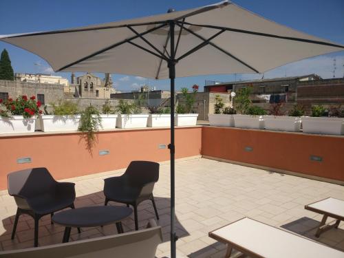 a patio with chairs and an umbrella on a roof at La Casa Dei Nonni in Matera
