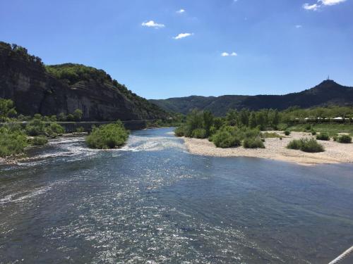 a river with a bridge in the background at Holiday Home in Sampzon near Ardeche River in Sampzon