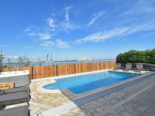 een zwembad met stoelen en een houten hek bij Luxury holiday home with private pool in Le Grau-du-Roi