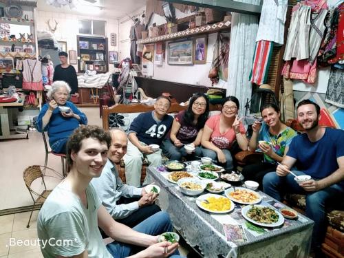 Eine Gruppe von Menschen, die an einem Tisch sitzen und Essen essen. in der Unterkunft Dai Yi Shia B&B in Fushi