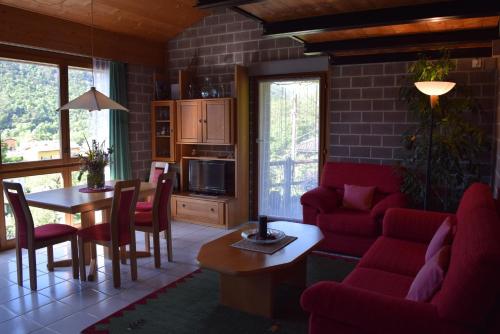un soggiorno con divano rosso e tavolo di Casa Sot Gesa a Verscio