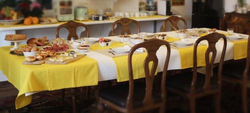a table with a yellow table cloth with food on it at Le Ginestre in Massa