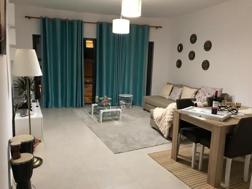 ein Wohnzimmer mit grünen Vorhängen und einem Sofa in der Unterkunft Prazeres do Golf in Quinta do Anjo